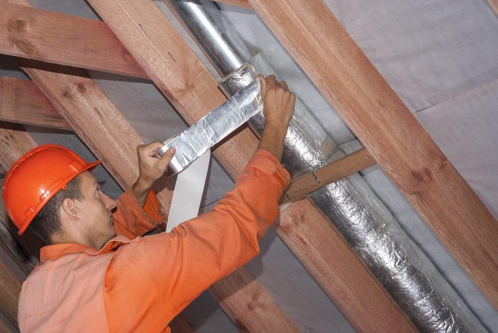 Worker insulating the air ducts